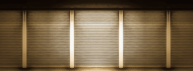 Closed gold color steel shutter door of warehouse, storage or storefront for metal door background...