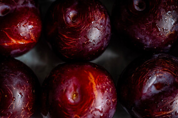 Many delicious ripe plums as background, closeup. Fresh plum with water splashes and drops.