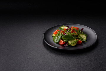 Delicious fresh salad with arugula, spinach, cucumber and cherry tomatoes in a ceramic plate