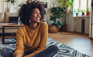 Young woman with a beautiful afro hairstyle, exuding happiness as she sits on the floor of her plant-adorned living space. - obrazy, fototapety, plakaty
