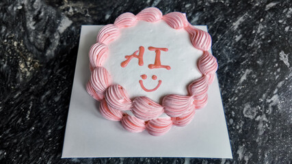 Top-down view of a festive circular cake with pink frosting and AI inscription, ideal for technology celebration or coding event promotions, with space for additional text on marble background