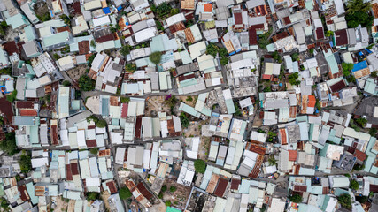 Aerial view of a dense urban area with closely packed houses and varied roofing, suitable as a...