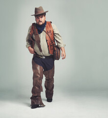Portrait, serious and criminal cowboy in studio mockup, outlaw and wild west character with pistol....