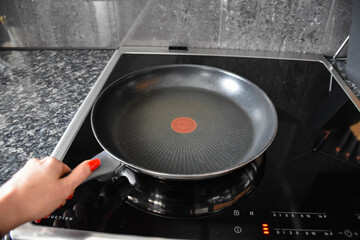 Teflon pans on the induction hob in the kitchen