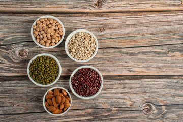 Mung beans, Red kidney beans, Chickpeas source and peeled barley in white cup on spoon wooden on wood background