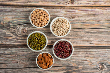 Mung beans, Red kidney beans, Chickpeas source and peeled barley in white cup on spoon wooden on wood background