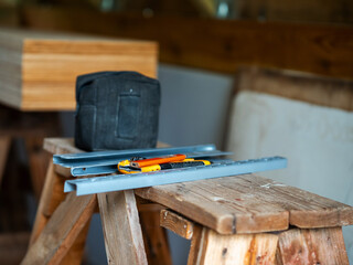 Stack of ply wood and carpenter tools, Roof elements out of focus in the background. Building or...