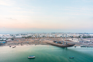 Fototapeta na wymiar Panoramic view on west part of the Sur city in golden hour. Al Ayjah Bridge, Sur, Oman