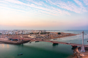 Panoramic view on west part of the Sur city in golden hour. Al Ayjah Bridge, Sur, Oman