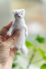 Knitted arctic fox  toy in hand - 743657163