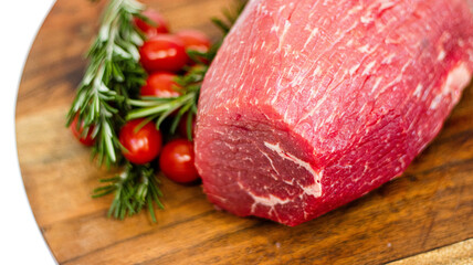 raw beef steak with rosemary on wooden board