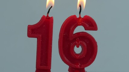 close up on timelapse melting a red number sixteenth birthday candle on a white background.

