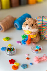 Knitted hamster toy with yarn and knitting accessories