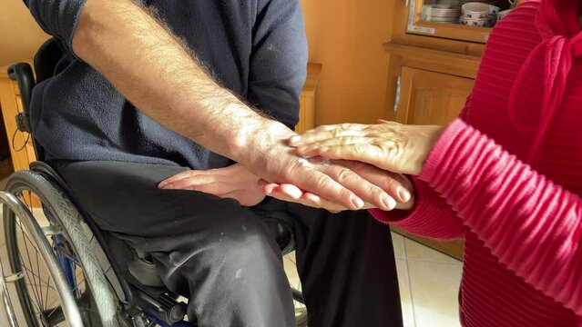 nurse is helping the man in wheelchair by body care