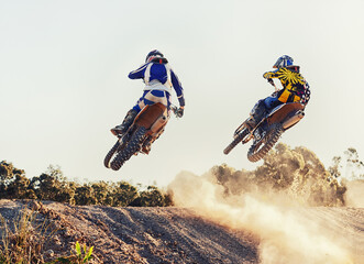 Sport, racer and dirtbike in action for competition on dirt road with performance, challenge and adventure. Motocross, motorbike or motorcycle driver with helmet on offroad course and path for racing - obrazy, fototapety, plakaty
