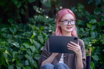 Cute pink hair girl drawing on digital tablet in garden, Woman Doing Freelance Work in Garden, woman with digital tablet with graffiti artwork