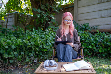Cute pink hair girl drawing on digital tablet in garden, Woman Doing Freelance Work in Garden, woman with digital tablet with graffiti artwork