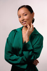 Close up portrait of a beautiful elegant asia woman with stylish jewelry on a white background. Asian cute girl in green dress. Beautiful girl with jewelry.