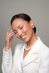Close up portrait of a beautiful elegant asia woman with stylish jewelry on a white background. Asian cute girl in white jacket. Beautiful girl with jewelry.