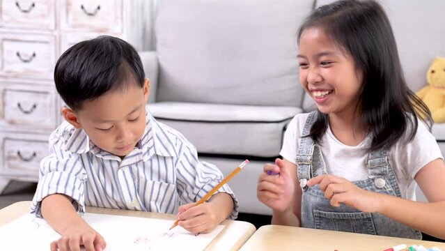Happy sibling brother and sister laughing playing drawing together at home weekend activities, preschool kids enjoy carefree bonding relationship explore learning digital technology in smartphone