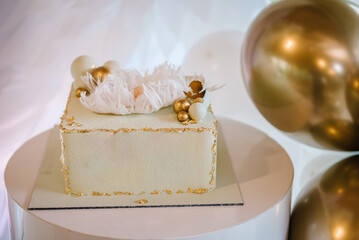 Trendy cake with figure newborn, wings angel and golden decor. Celebration baptism concept. Cake on...
