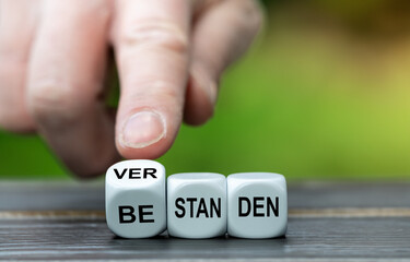 Hand dreht Würfel und ändert das Wort 'bestanden'  in 'verstanden'. Symbol dafür etwas zu...