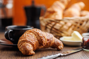 Baked tasty croissant on wooden table.
