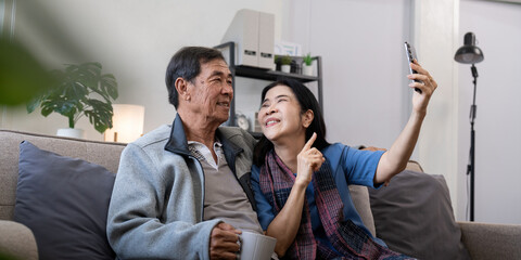 Happy old couple elderly taking selfie on cellphone, senior mature spouses wife and husband laughing holding phone make self portrait on smartphone camera