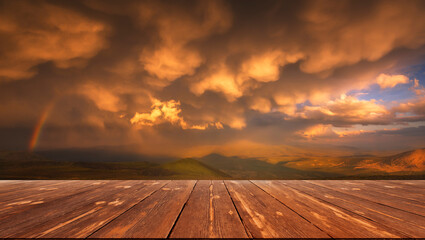 The Sky With Clouds And A Rainbow After The Rain with empty wooden table. Natural template landscape