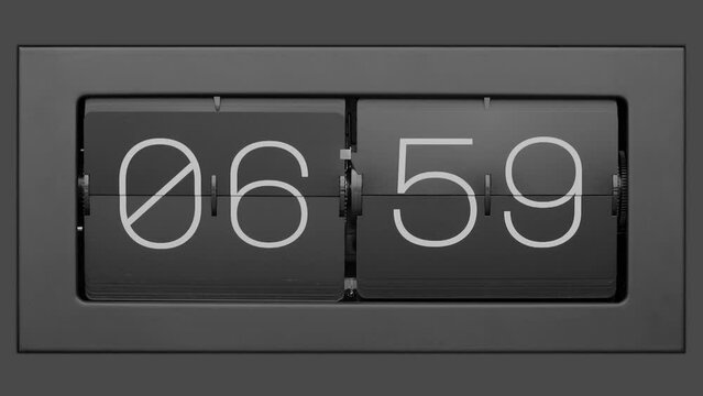 Flip clock quickly flips. Retro flip clock changing from 06:59 to 07:00. Slow motion.  