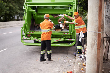 Men, garbage truck and city sidewalk for collection service for public pollution for recycling,...