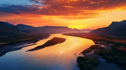 Poster Breathtaking sunset over a winding river with mountainous landscape in the background. © GreenMOM
