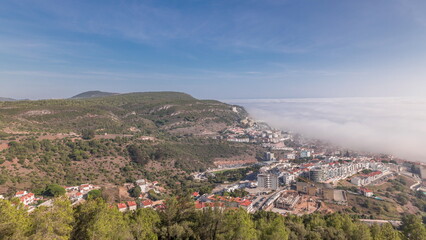 Fototapeta na wymiar Panorama showing aerial View of Sesimbra Town and Port covered by fog timelapse, Portugal.