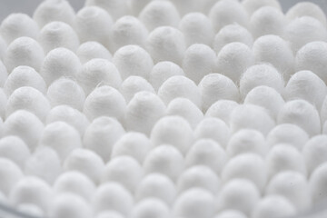 Macro view of white cotton ear cleaning buds arranged in white backgroud nicely in a container