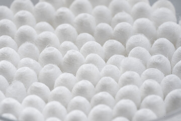 Macro view of white cotton ear cleaning buds arranged in white backgroud nicely in a container