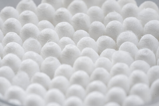 Macro view of white cotton ear cleaning buds arranged in white backgroud nicely in a container © subhashpb