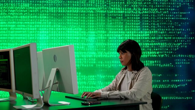 IT specialist against big digital screen. African american woman programmer works on computer in front of screen digital code data process.