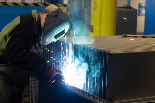 A welder in a mask welds a structure
