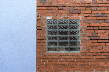 Architectural detail of brickwork, blue plaster and glass blocks