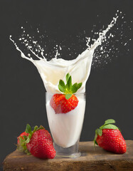 Splash of a strawberry falling into the glass with cream, on a black background - 743703932