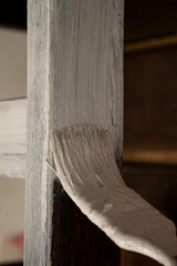 A wooden board with a brush with white paint.