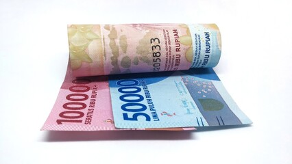 a roll of Indonesian banknotes worth IDR 100,000 and IDR 50,000. Indonesian currency rupiah isolated on white background