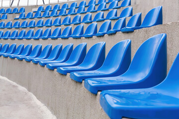 Plastic blue seats on street auditorium or stadium. No people, side view