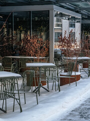 Metal outdoor furniture on a snowy summer terrace