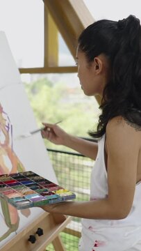 Brunette woman paints silhouette of two models