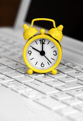 Alarm clock on a laptop computer keyboard. Daylight savings time background. - 743739180