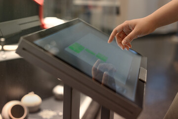 girl uses touchscreen terminal - obrazy, fototapety, plakaty
