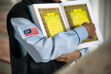 Malaysian professional holding a book with national flag