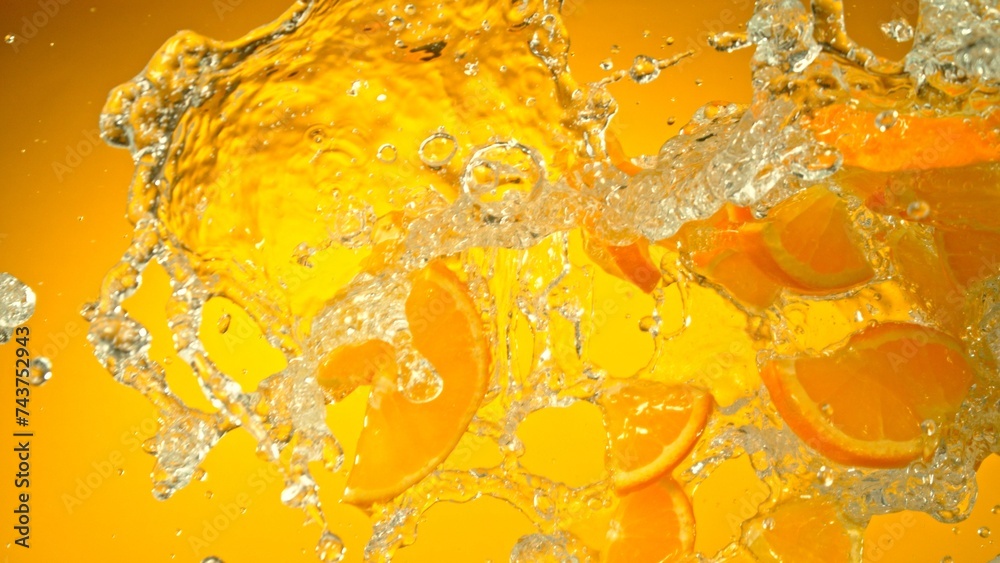 Aufkleber freeze motion of flying slices of oranges with splashing water.