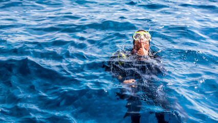 diving instructor entertains tourists by fountains opening from the mouth depicting a whale © Sofiia